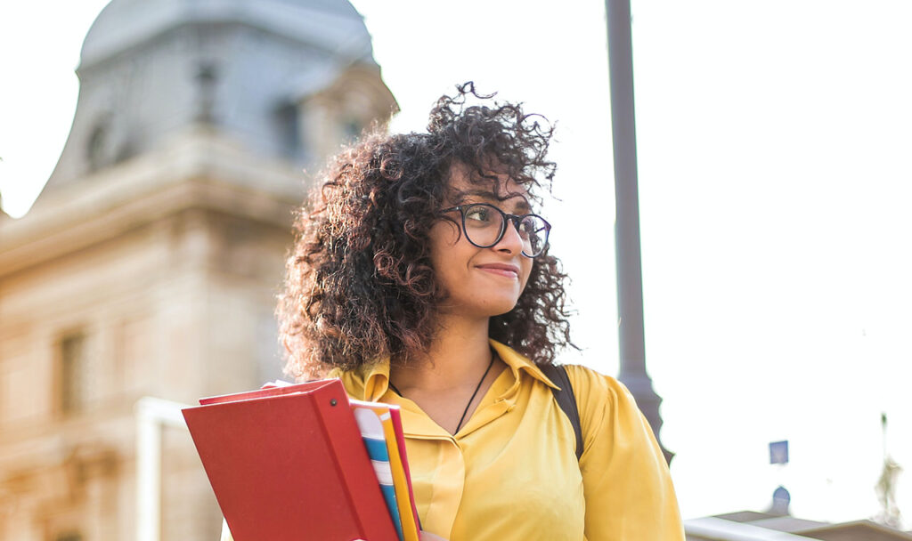 Female student outdoors Photo by Andrea Piacquadio: https://www.pexels.com/photo/woman-in-yellow-jacket-holding-books-3762800/
